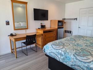 a hotel room with a desk and a bed and a television at Rodeway Inn Alameda-Oakland in Alameda