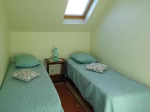 two twin beds in a room with a window at Holiday Home by Kerleven Beach, France in La Forêt-Fouesnant