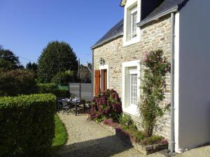 a brick house with flowers on the side of it at Holiday Home by Kerleven Beach, France in La Forêt-Fouesnant