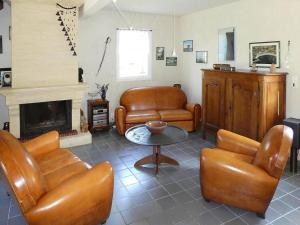 a living room with leather furniture and a fireplace at Holiday Home in Piriac near Sandy Beach in Piriac-sur-Mer