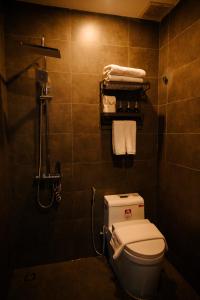 ein Badezimmer mit Toilette und Dusche mit Handtüchern in der Unterkunft Charm House Hue in Hue