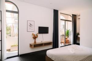 ein Schlafzimmer mit einem Bett und einem Fernseher an der Wand in der Unterkunft Charm House Hue in Hue