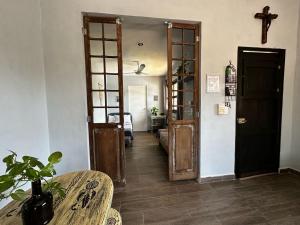 a hallway with a door and a table and a cross at Casa Quinta Luna in Homún