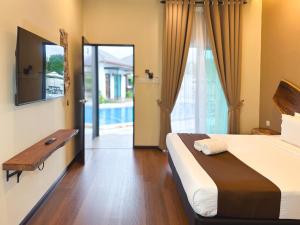 a bedroom with a bed and a tv and a pool at Smilang Chalet in Kuala Terengganu