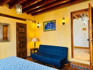 a blue bed in a room with a blue couch at La Casa Veintidós in Guanajuato