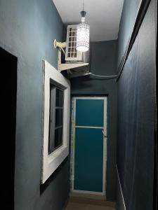 a hallway with a blue wall and a door and a window at Dersym Apartment in Port Harcourt +18 photos