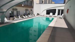 a swimming pool in a building with chairs around it at Departamento Casa de playa in Necochea