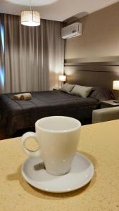 a coffee cup sitting on a table in a bedroom at Departamento Casa de playa in Necochea