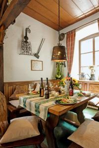 ein Esszimmer mit einem Tisch mit Speisen und Weinflaschen in der Unterkunft Gutsschänke Sennerhof in Oberwesel