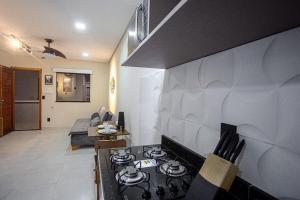 a kitchen and living room with a stove top oven at Residencial Bianca, Ap 07 - TERREO in Aracaju