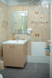 a bathroom with a sink and a shower with a mirror at Fishta apartments Q5 32 in Velipojë