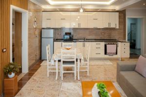 a kitchen and living room with a table and chairs at Fishta apartments Q5 32 in Velipojë