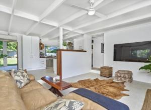 un salon avec un canapé et une télévision à écran plat dans l'établissement Palm Springs Bungalow, à Trinity Beach