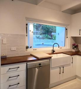 une cuisine avec un évier et une fenêtre dans l'établissement Palm Springs Bungalow, à Trinity Beach 25 autres photos