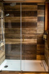 a shower with a wooden wall in a bathroom at NI-NEWEN Hotel & Lodge in Pucón