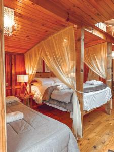 a bedroom with two beds in a room with wooden ceilings at Pousada Quinta das cores in Urubici