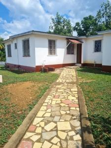 a house with a stone path in front of it at Linstead Riverview Retreat in Linstead