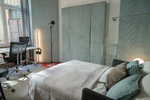 ベルリンにあるDesign Loft mit Musikstudio in Berlin Mitteのベッドと机とテーブルのある寝室