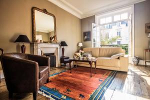 a living room with a couch and a mirror at Villa Athanaze in Saint Malo