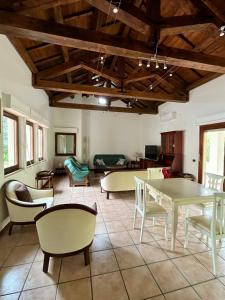 a living room with tables and chairs and a couch at Villetta Regina in Teulada