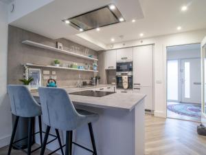 a kitchen with two bar stools and a counter top at Fabulous Festival Park Home Private Parking Garden Pass the Keys in Glasgow