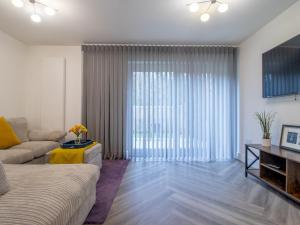 a living room with a couch and a large window at Fabulous Festival Park Home Private Parking Garden Pass the Keys in Glasgow