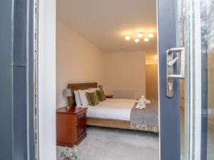 a bedroom with a bed and a door leading into a room at Fabulous Festival Park Home Private Parking Garden Pass the Keys in Glasgow