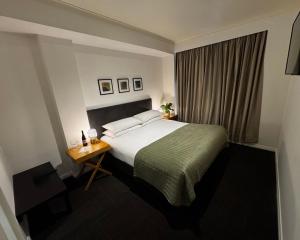 a hotel room with a bed and a table at The Richmond Hotel - Adelaide in Adelaide