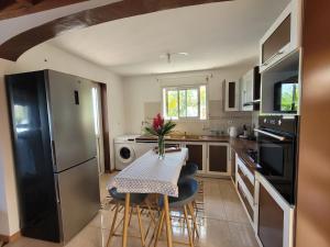 a kitchen with a table with chairs and a refrigerator at Villa Mont Horizon in Saint-Pierre