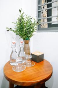 einen Holztisch mit Brille und eine Vase mit Pflanze in der Unterkunft Charm House Hue in Hue