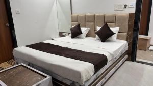 a bedroom with a large bed with black and white pillows at HOTEl SHREE ASHTVINAYAK GRAND in Mandlā