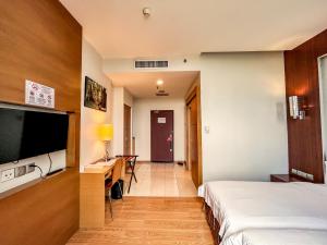 a hotel room with two beds and a desk and a television at Courtyard Hotel 1Borneo in Kota Kinabalu +25 photos