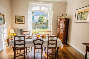 ein Esszimmer mit einem Tisch, Stühlen und einem Fenster in der Unterkunft Villa Athanaze in Saint-Malo