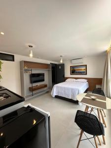 a hotel room with a bed and a television at Bessa Flat Conforto à 180m do Mar - Storey Luxor in João Pessoa