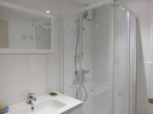 Un baño blanco con ducha y lavabo. en Maison spacieuse à 400m de la plage des Govelins, vue mer - FR-1-639-138, en Saint-Gildas-de-Rhuys 16 fotos más