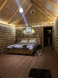 a bedroom with a bed in a brick wall at La Renada in Mawphlang