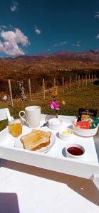 a white table with a plate of food on it at Esencia Cabaña in Potrerillos