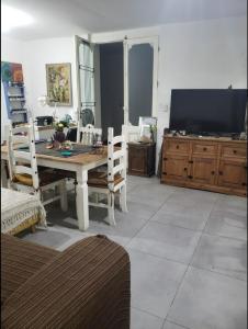a living room with a table and chairs and a television at Habitaciones Casa Compartida in Montevideo