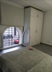 a bedroom with a bed and a large window at Habitaciones Casa Compartida in Montevideo