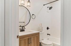 a bathroom with a sink and a toilet and a tub at West Wildwood Beach House in Wildwood +27 photos