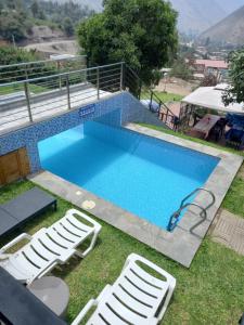 a swimming pool with two lawn chairs and a swimming pool at CASA DE CAMPO CON PISCINA EN COCACHACRA HUAROCHIRI SOL TODO EL AÑo in Cocachacra