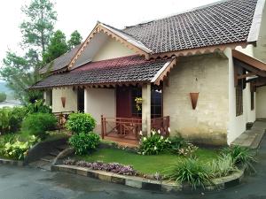 a small house with a gate and a porch at Hotel New Pesona Anggraini in Brujul