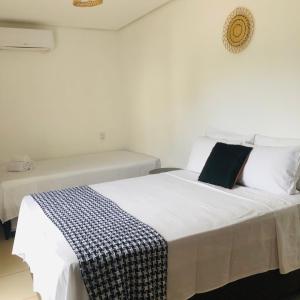 Una cama blanca con una manta blanca y negra encima. en Suite Front Jeri, en Jericoacoara