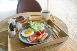a tray with a plate of breakfast food and a cup of coffee at Barn Sampran Resort บ้านสามพรานรีสอร์ท in Nakhon Pathom