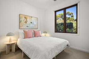 a white bedroom with a bed and a window at Banksia Dunes Your Coastal Escape in Normanville in Normanville +37 photos
