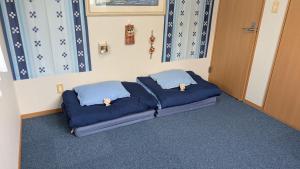 うるま市にあるIndependent House 沖縄VILLA YASUMIBA Okinawa Urumaの青い枕が備わる客室のベッド1台分です。