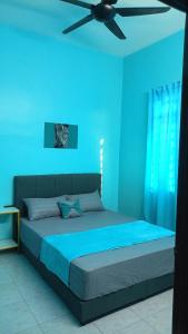 a blue bedroom with a bed with a ceiling fan at Homestay RestUI, Kepala Batas Penang, 4km dari Tol Bertam in Kepala Batas