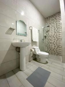 Colonial zone 3 bed 3 rooms balcony في سانتو دومينغو: حمام أبيض مع حوض ومرحاض