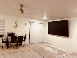 a living room with a table and a television on the wall at Entire Basement in Puyallup, WA in Puyallup