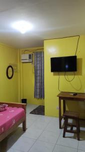 Una televisión o centro de entretenimiento en R & R (Rest & Relax) Guesthouse